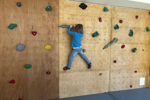 Ein Kind probiert sich an der Kletterwand