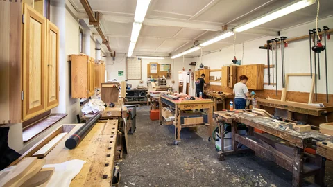 Zwei Personen arbeiten in der Werkstatt mit Holz