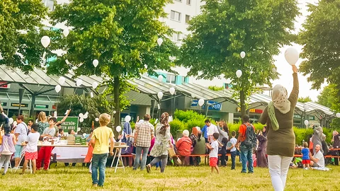 Kinder spielen mit Luftballons auf einer Wiese