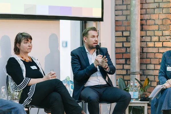 Auf einer Bühne des SozDia Neujharsempfangs der Abgeordnete Danny Freymark der CDU mit einemm Mikrofon.