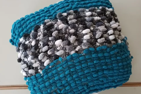 Ein Blaues gestricketes Kissen mit Schachbrettmuster