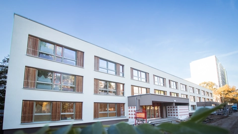 Außendarstellung der neu renovierten Kita Sonnenschein. Blauer Himmel, die Sonne scheint.