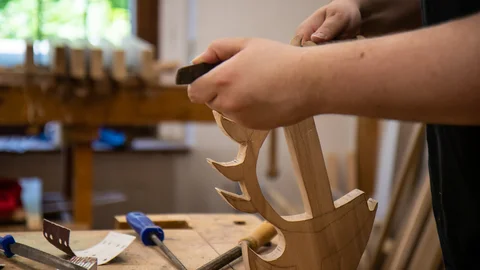 Person hält kreativ gesägtes Holzstück in der Hand