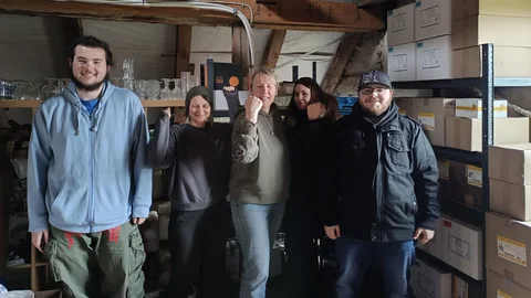 Fünf Personen lachen ins Foto und zeigen das sie zusammen etwas geschafft haben