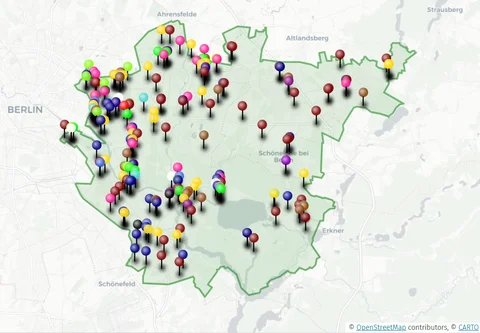 Eine Karte einer grün umrandeten Region östlich von Berlin, mit vielen bunten Stecknadeln, die verschiedene Orte kennzeichnen.